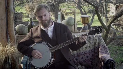 Man with a beard is intently playing the banjo Stock Footage 164242510