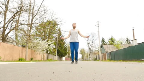 A man with a beard jumping on a rope. The camera is moving slowly. Slow Motion Stock Footage 88905694