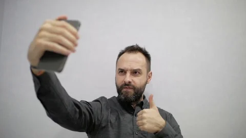A man with a beard makes a selfie on the phone Stock Footage 98808614