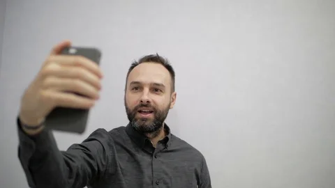A man with a beard makes a selfie on the phone Stock Footage 98808642