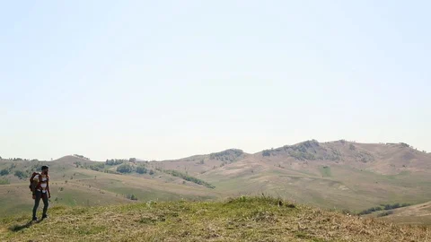 Man with beard mustache with a backpack goes mountains summer looks around. Stock Footage 111237656