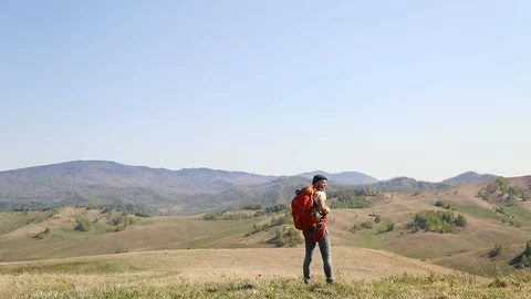 Man with beard mustache with a backpack goes mountains summer looks around. Stock Footage 111237725