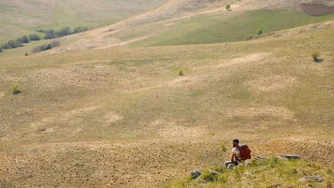 Man with a beard. Mustache backpack. Sitting mountains summer. looks around. Stock Footage 111237767