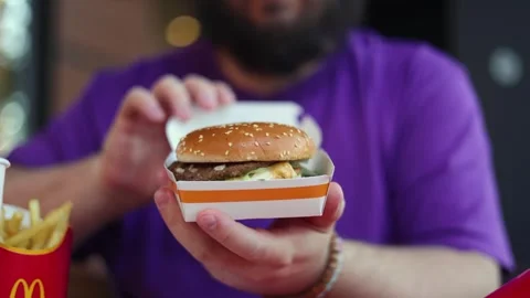 Man with beard opens a box with Big Mac burger with football ball Stock Footage 338312919