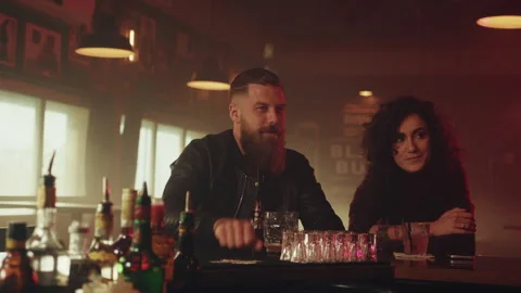 Man with beard ordering two drinks from bartender Stock Footage 275122135