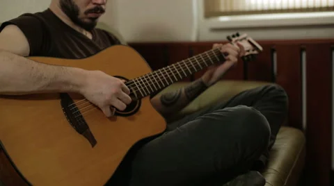 A man with a beard playing the guitar Stock Footage 61886970