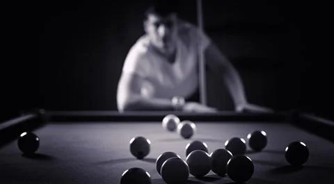 A man with a beard plays a big billiard. Party in a 12-foot pool. Billiards.. Stock Photos