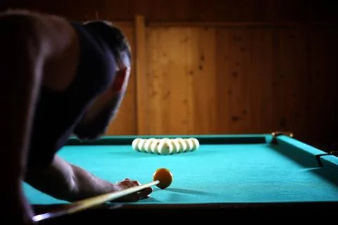 A man with a beard plays a big billiard. Party in a 12-foot pool. Billiards.. Stock Photos