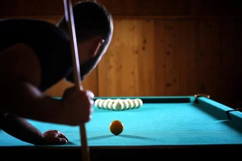 A man with a beard plays a big billiard. Party in a 12-foot pool. Billiards.. Stock Photos
