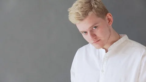 A man with a beard pointing to a copy of space. Young man in shirt pointing away Stock Footage 79709597