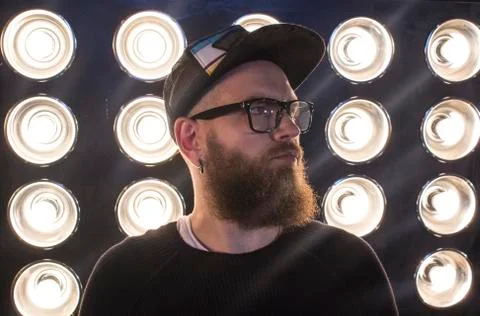 Man with a beard. Portrait of a bearded guy in a cap against a backdrop of .. Stock Photos