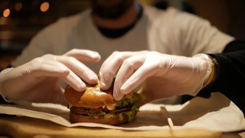 Man with a beard preparing to eat a burger. cheeseburger Stock Footage 99822439