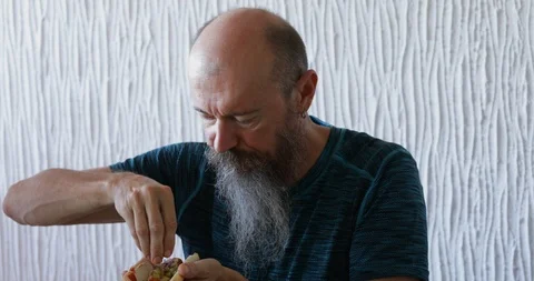 Man with beard preparing hot dog, sprinkling chopped onions and pickled cucumber Stock Footage 113052685