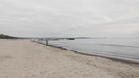 Man with Beard in Protective Face Mask Running by the Beach at Dusk - Wide Dolly Stock Footage 130729385