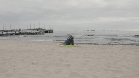 Man with Beard in Protective Face Mask Performing Side Elbow Plank on Seashore Stock Footage 130731961