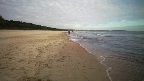 Man with Beard in Protective Face Mask Running by the Beach at Dusk - Wide Shot Stock Footage 130733146
