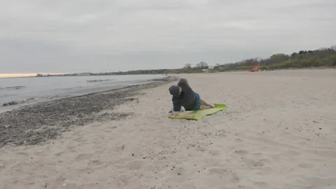 Man with Beard in Protective Face Mask Performing Side Elbow Plank on Seashore Stock Footage 130737704