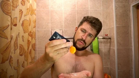 A man with a beard puts on the face after shaving cream Stockbeeldmateriaal 93820052