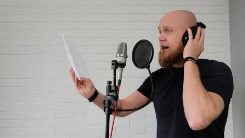 A man with a beard reads paper text in a home music studio. Close-up. Stock Footage 139649318