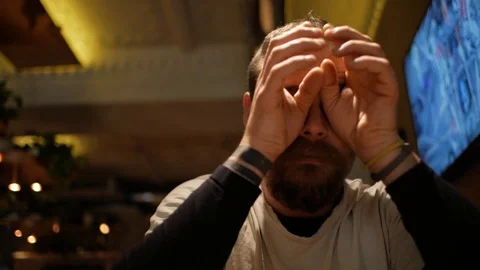 A man with a beard rubs his eyes Stock Footage 99779261