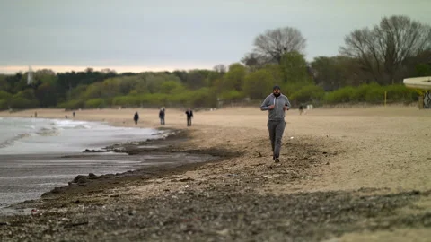 Man with Beard Running by the Beach at Dusk - Wide Shot Stock Footage 130727957