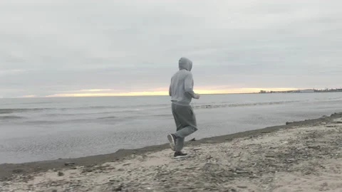 Man with Beard Running by the Beach at Dusk - Wide Dolly Shot Stock-Footage 130728844