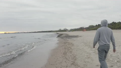 Man with Beard Running by the Beach at Dusk - Wide Dolly Shot Video stock 130735375
