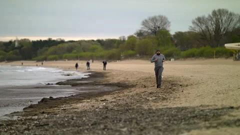 Man with Beard Running by the Beach at Dusk - Wide Shot Stock Footage 130735736