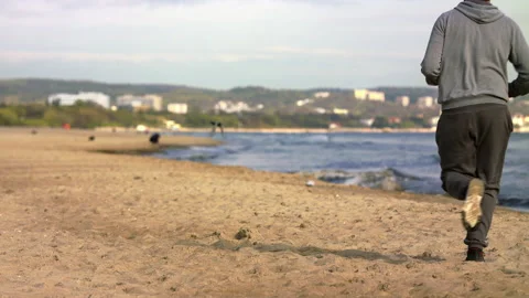 Man with Beard Running by the Beach at Dusk - Wide Shot Stock Footage 130736807
