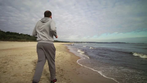Man with Beard Running by the Beach at Dusk - Wide Shot Stock Footage 130739031