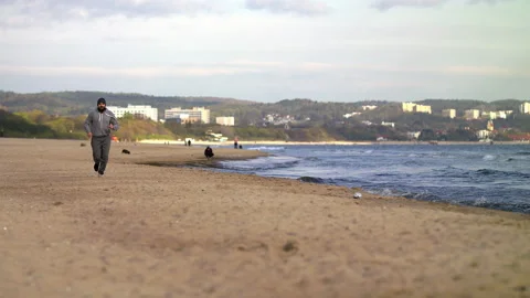 Man with Beard Running by the Beach at Dusk - Wide Shot Stock Footage 130739814
