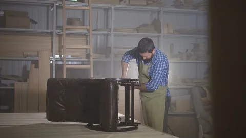 Man with a beard in a shirt in the workshop Stock Footage 98463430