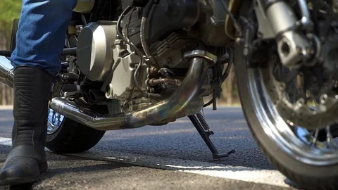  A man with a beard sits on his motorcycle and looks into the distance. Close-up Video stock 88499780