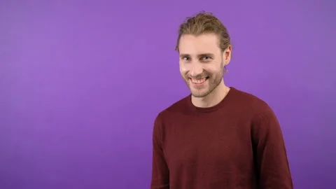 Man with a beard with a smile looks at the camera and shows a hand gesture of Stock Footage 147203143