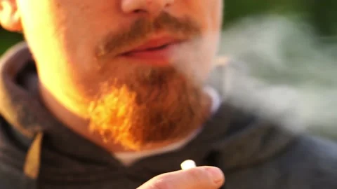 A man with a beard smokes cigarettes. pernicious habits. Stock Footage 142384604