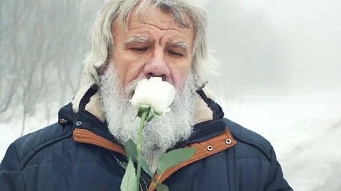 A man with a beard sniffs and gives a white rose Stock Footage 85895225
