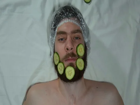Man with a beard in a spa salon. A man with cucumbers on a beard. Stock Footage 121084095