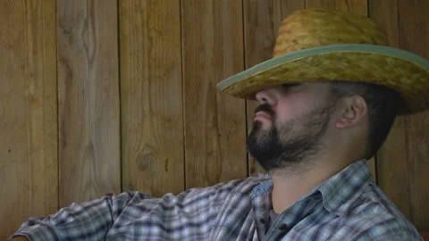 A man with a beard in a straw hat sleeps 4K Stock-Footage 95924080