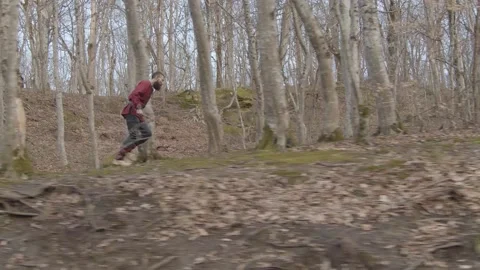 Man with beard in suit of Viking with axes in hands runs through forest Stock Footage 132992467