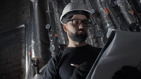 Man with beard takes notes, looks at the sensor. Vídeo Stock 102373901