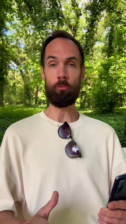 Man with Beard Talking On Camera Outdoors in Sunny Nature Stock Footage 308964777