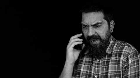 Man with beard talking on the phone screaming and shouting angry and furious Stock Footage 157925132