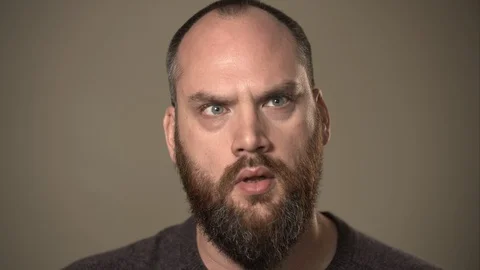 Man with beard trying to decide a difficult choice, or confused by a problem. Vídeo Stock 129068341