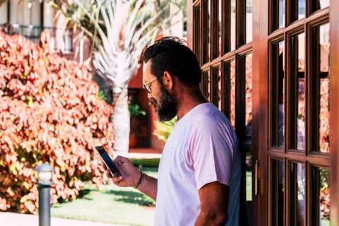 Man with beard use technology internet connection on a modern phone in outdoo Stock Photos