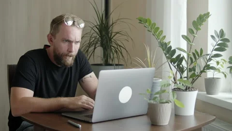 Man with a beard uses a computer Stock Footage 157890889