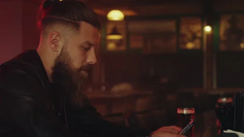 Man with beard using his phone in bar Stock Footage 275122890