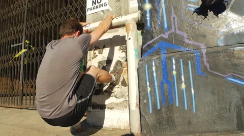 A man with a beard using a wall and urban environment to work out, slow motion. Stock Footage 68537047