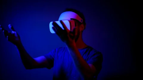 A man with a beard in a VR helmet interacts with virtual reality and views media Stock Footage 121387345