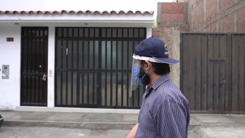 A man with a beard walking with his mask and face shield Видео 140556997
