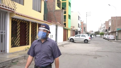 A man with a beard walking with his mask and face shield 스톡 동영상 140557369